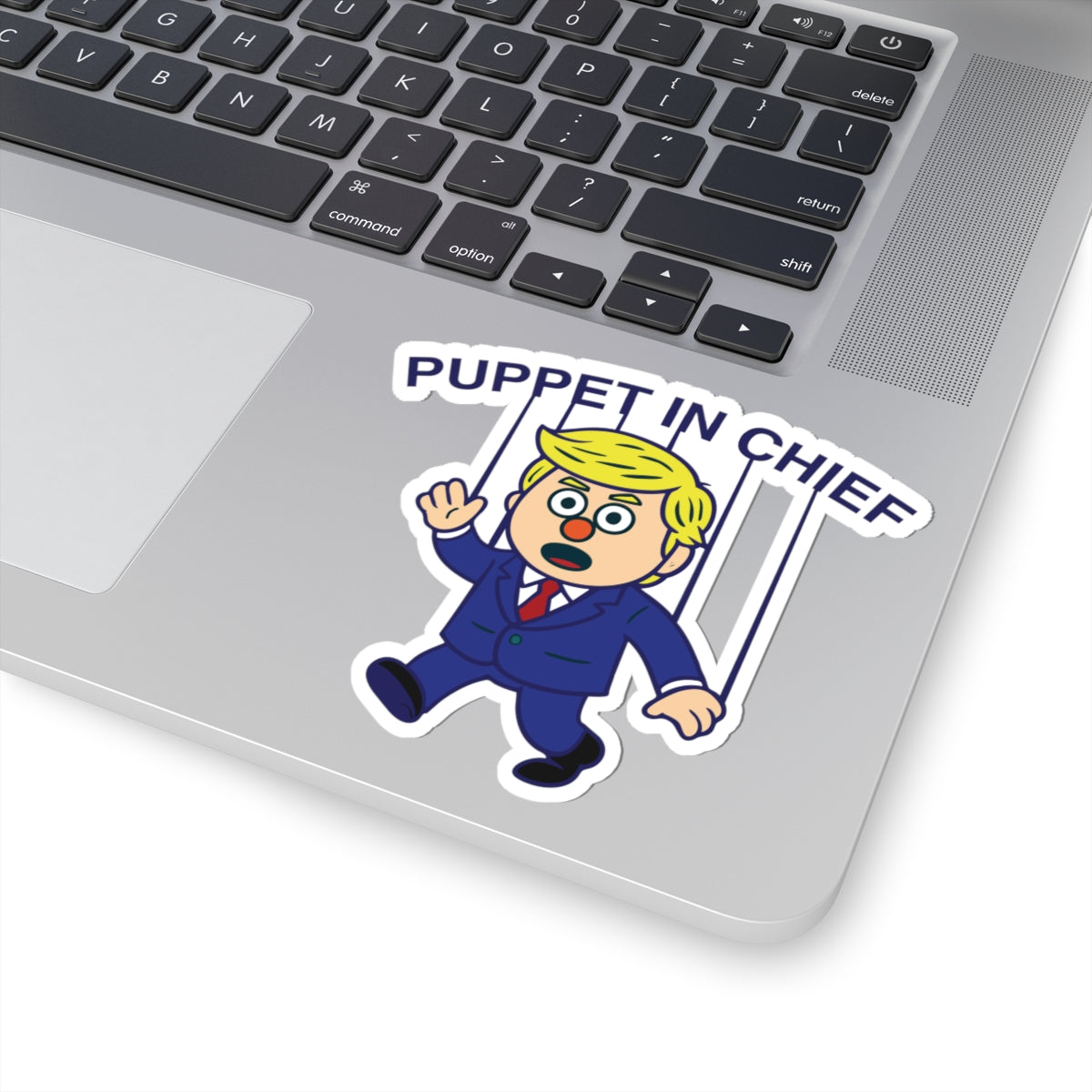 Political Humor Sticker - Puppet in Chief showing cartoon character with blonde hair controlled by strings on laptop surface