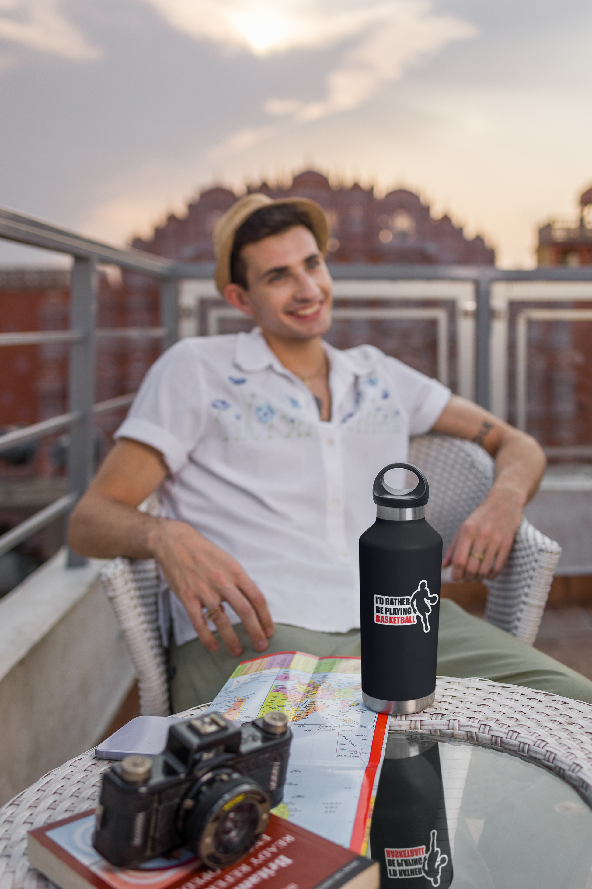 Kiss Sticker - Basketball on black water bottle featuring player silhouette and bold red and white text on outdoor table