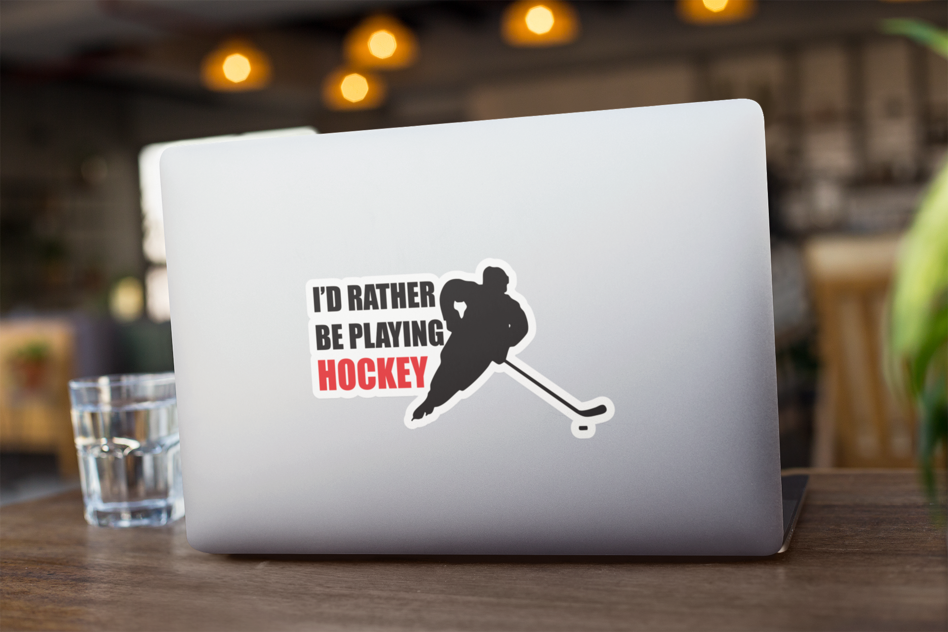 Kiss Sticker - Hockey with a player silhouette and bold text "I'd rather be playing HOCKEY" on a silver laptop surface
