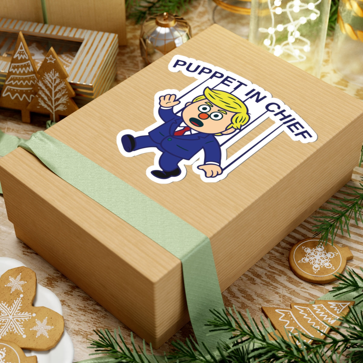 Political Humor Sticker - Puppet in Chief showing cartoon puppet with blonde hair and strings on a gift-wrapped box
